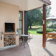 Exterior covered patio with fireplace and furniture.