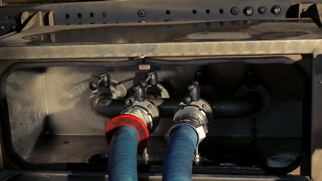 The man opens the valve taps/Technician open valve on truck/Milk tank/Dairy industry machinery/Food processing industry
