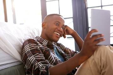 Relaxed young man using digital tablet at home