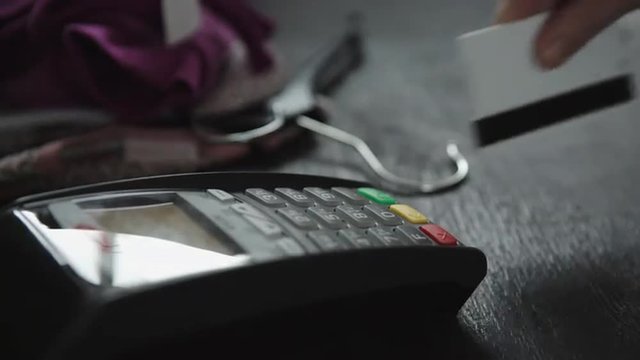 hand swiping credit card in store