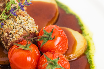 Tomatoes confit and baked potatoes close up.