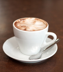 Cappuccino in a white cup on the table