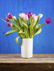 Tulips in vase, rustic blue background