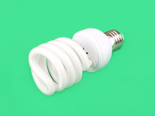 Energy saving fluorescent light bulb on green background