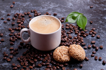 cup of fresh americano and cookies on coffee beans background