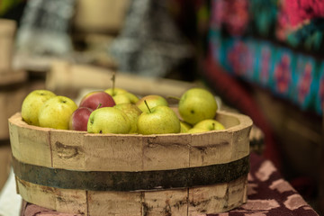 Green and red apples in a wooden dish