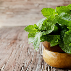 Fresh mint in a wooden bowl, selective focus