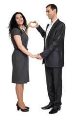 Happy couple dressed in strong classic dress, making heart shape from fingers, studio portrait on white