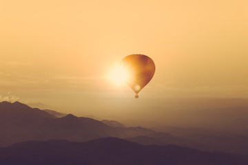 Silhouette of hot air balloon over mountain vintage color