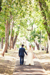 Fototapeta premium groom and bride walk in the wood outdoors