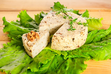 fresh cheese, greens with walnuts on wooden board
