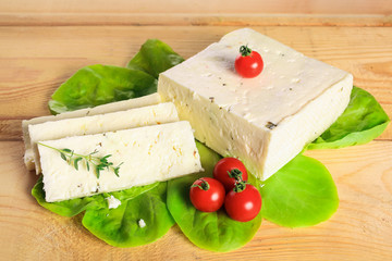 Fresh solid cream cheese on board with fresh herbs
