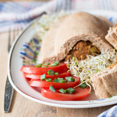 Yeast dough lentil pie with fressh tomato and alfalfa sprouts on polish folk plate. Square.