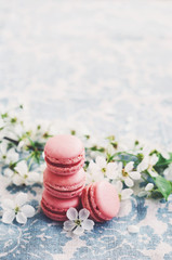 Fototapeta premium Pile of raspberry macaroons and cherry flowers