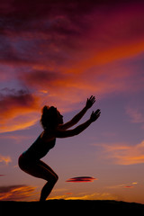 silhouette of a woman squat down reach up