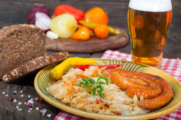 Grilled sausages with sauerkraut, homemade bread and glass of beer