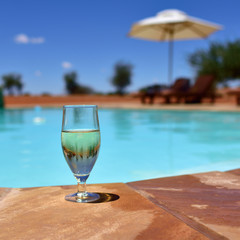 Glass of wine near swimming pool