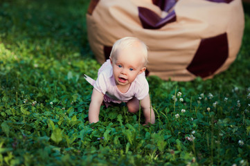 Smiling portrait cute baby-girl on green grass