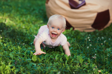 Smiling portrait cute baby-girl on green grass