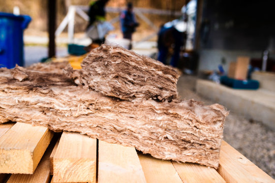 Pieces Of Glass Insulation Wool Laying On Wooden Beams