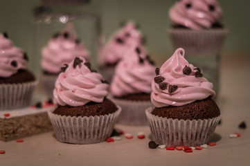 Chocolate muffins with pink whipped cream and cocoa nibs