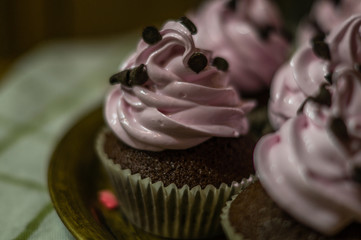 Chocolate muffins with pink whipped cream and cocoa nibs