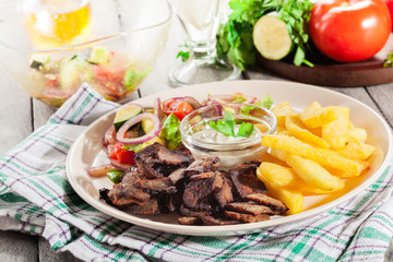 Grilled meat with French fries and fresh vegetables