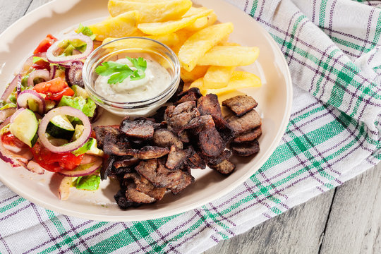 Grilled meat with French fries and fresh vegetables