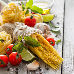Pasta and ingredients on rustic background
