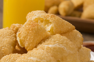 Pastel, a Brazilian snack, with a bar in the background. Cheese