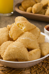 Pastel, a Brazilian snack, with a bar in the background. Cheese