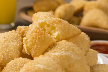 Pastel, a Brazilian snack, with a bar in the background. Cheese