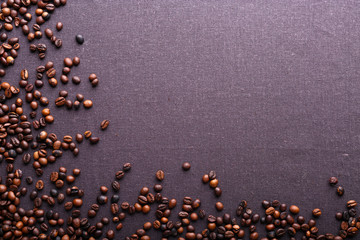 Roasted coffee beans on grey textile background