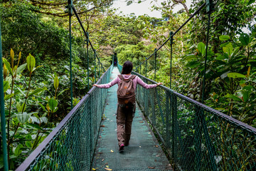 Fototapeta premium Dziewczyna na wiszący most w cloudforest - Monteverde, Kostaryka