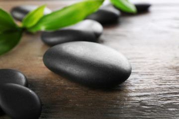 Spa stones and bamboo branch on wooden background