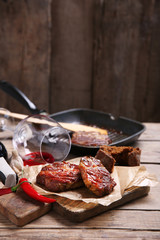 Roasted beef fillet and vegetables on cutting board, on wooden background