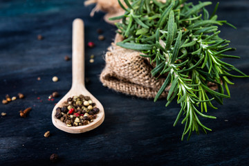 Fresh rosemary and peper on dark background.