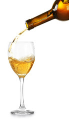 White wine pouring in glass, isolated on white