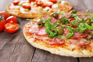 Delicious tasty pizzas with ingredients on table, closeup