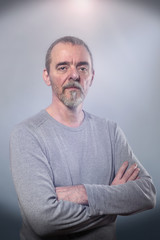 Obraz premium Portret uśmiechniętego mężczyzny ze skrzyżowanymi rękami