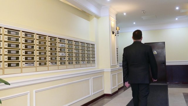 Apartment Concierge: Man Walking On Mailboxes Background