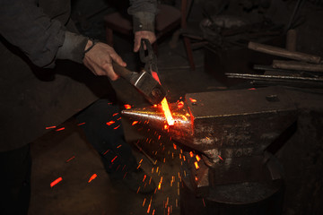 Blacksmith forfing hot iron - 103455219