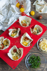 pizza on pita bread with tomatoes and cheese before baking and ingredients