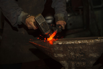 Blacksmith forfing hot iron - 103455270