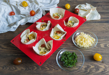 pizza on pita bread with tomatoes and cheese before baking and ingredients