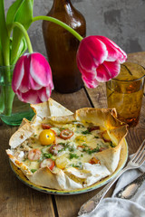 pizza on pita bread with tomatoes, cheese, and tulips