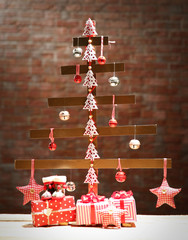 A handmade Christmas tree and presents on wall background