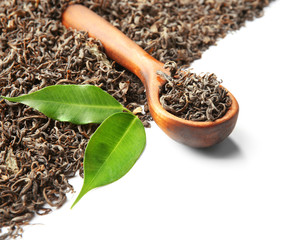 Wooden spoon with dry tea and green leaves, isolated on white