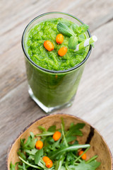 Rucola smoothie, on the grey  background.