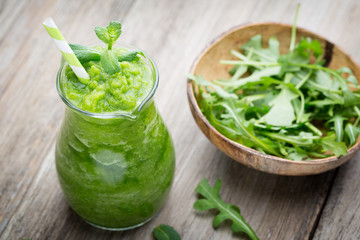 Rucola smoothie, on the grey  background.